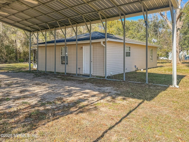 view of outdoor structure featuring a lawn and a carport