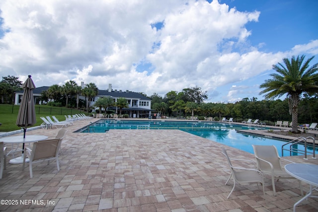 community pool featuring fence and a patio