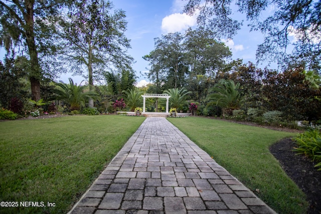 view of community featuring a lawn and a pergola