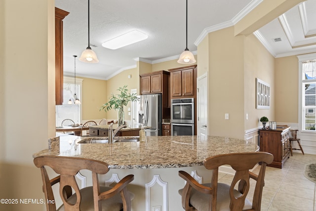 kitchen with light stone counters, stainless steel appliances, a sink, a kitchen breakfast bar, and ornamental molding