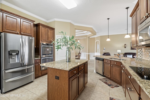 kitchen with light stone counters, crown molding, light tile patterned floors, appliances with stainless steel finishes, and a sink