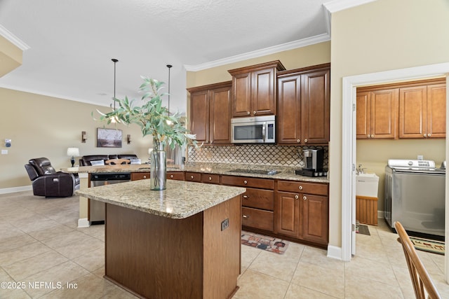 kitchen with appliances with stainless steel finishes, light tile patterned floors, ornamental molding, and separate washer and dryer