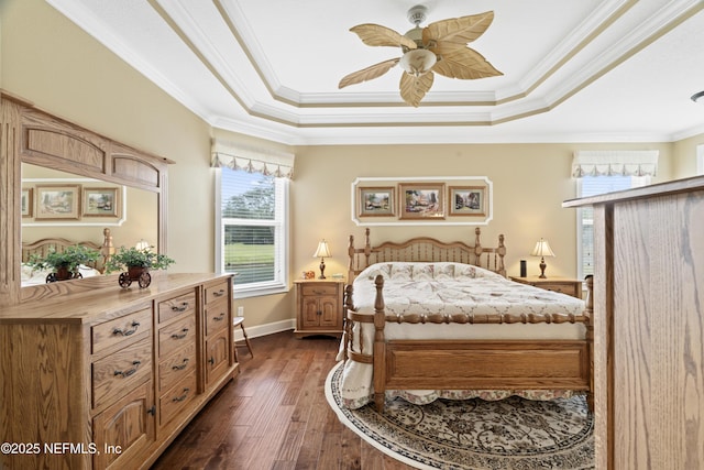 bedroom featuring dark wood-type flooring, a tray ceiling, and ornamental molding