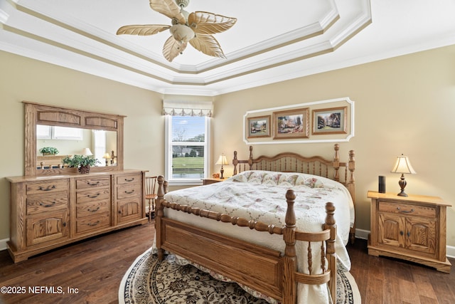 bedroom featuring dark wood-type flooring, a raised ceiling, crown molding, and a ceiling fan