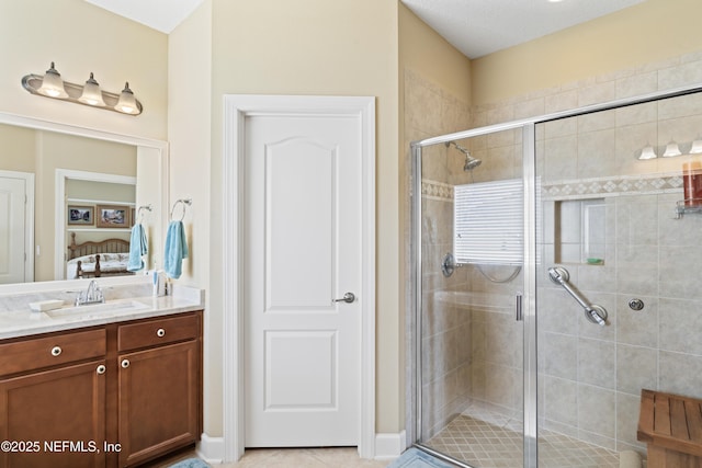 bathroom with tile patterned floors, a shower stall, ensuite bathroom, and vanity