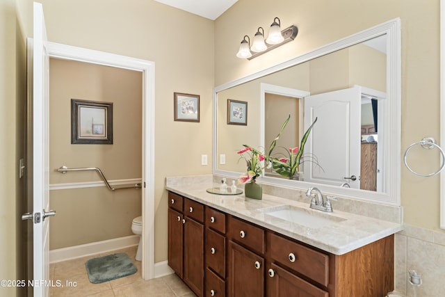 full bath with toilet, tile patterned flooring, double vanity, and a sink