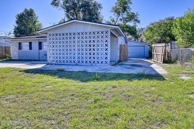 view of front facade with a front lawn, an outdoor structure, and a garage