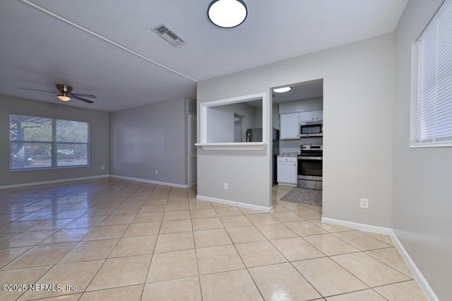 unfurnished room featuring light tile patterned floors and ceiling fan