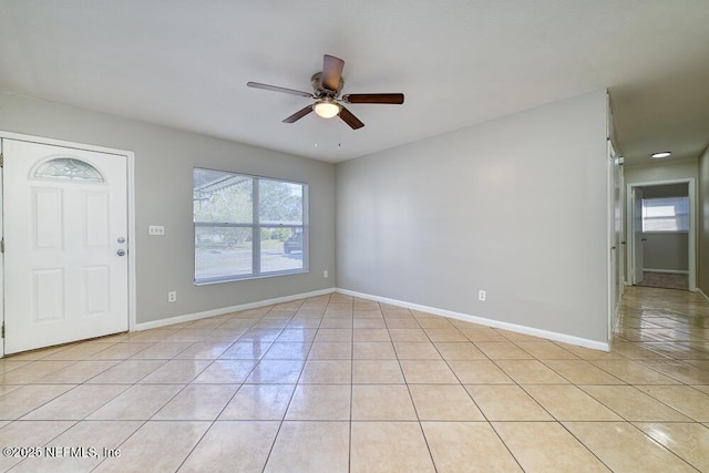 foyer entrance with ceiling fan and light tile patterned flooring