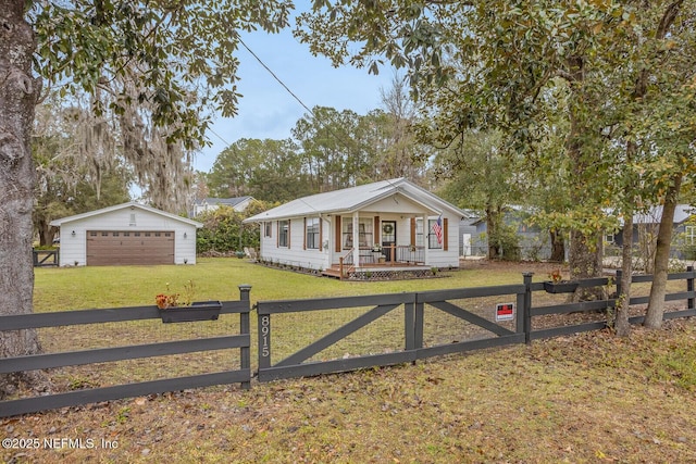 view of front of house featuring an outbuilding, a front yard, a porch, and a garage