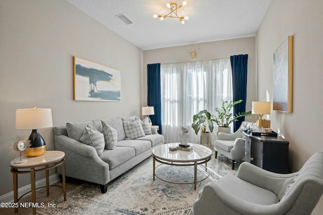 living room with a textured ceiling and a notable chandelier