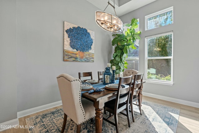 dining area featuring light hardwood / wood-style floors, an inviting chandelier, and a wealth of natural light