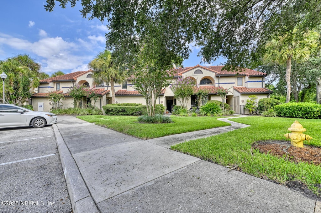 mediterranean / spanish-style home featuring a front lawn