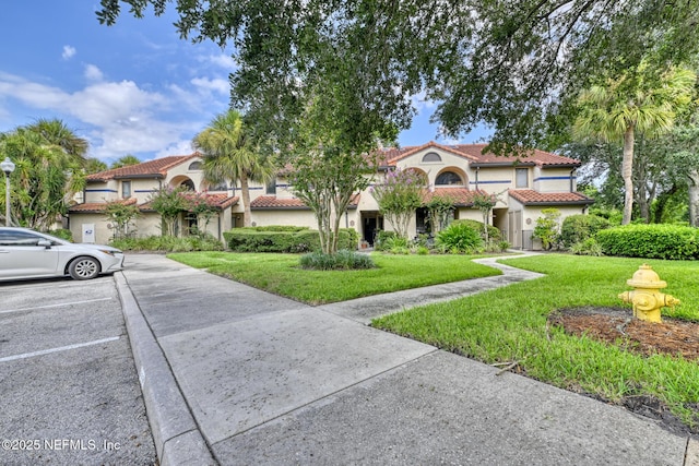 mediterranean / spanish-style house featuring a front lawn