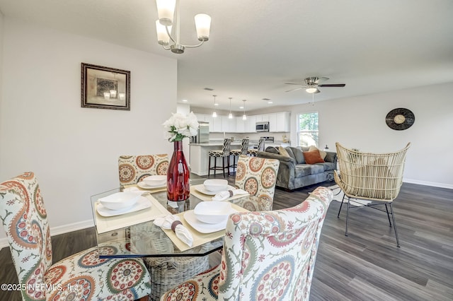 dining area with ceiling fan with notable chandelier and dark hardwood / wood-style flooring