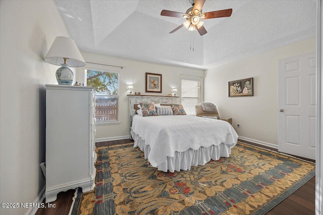 bedroom featuring ceiling fan, a tray ceiling, and multiple windows