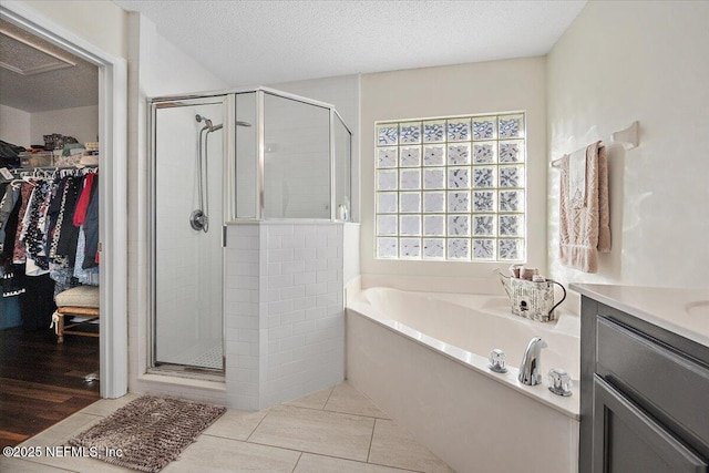 bathroom featuring a textured ceiling, shower with separate bathtub, tile patterned floors, and plenty of natural light