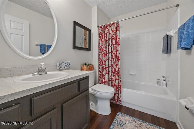 full bathroom with hardwood / wood-style flooring, a textured ceiling, shower / bath combo with shower curtain, and vanity