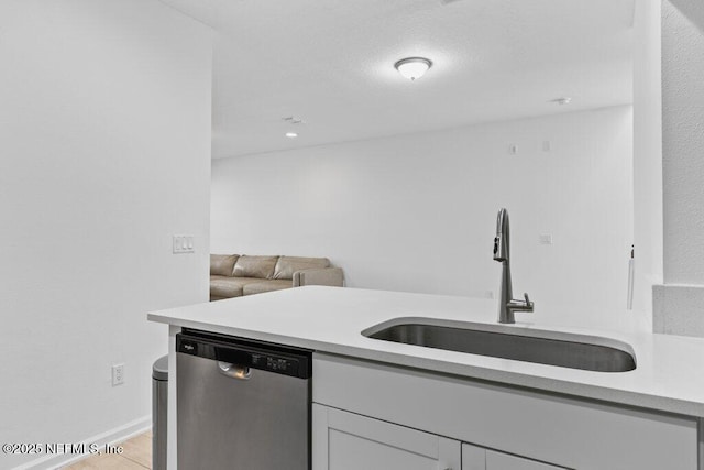 kitchen featuring stainless steel dishwasher, light tile patterned floors, and sink