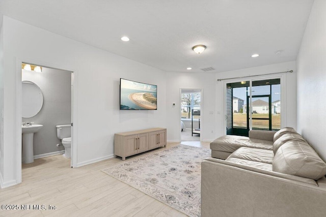 living room with light hardwood / wood-style flooring and sink