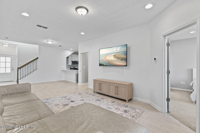 living room featuring a textured ceiling and light wood-type flooring