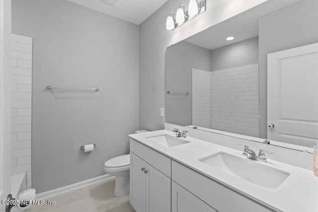 bathroom with tiled shower, vanity, and toilet