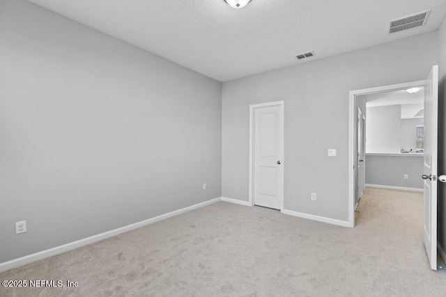 unfurnished bedroom with light carpet and a textured ceiling