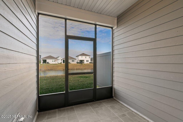 unfurnished sunroom with a water view and a healthy amount of sunlight