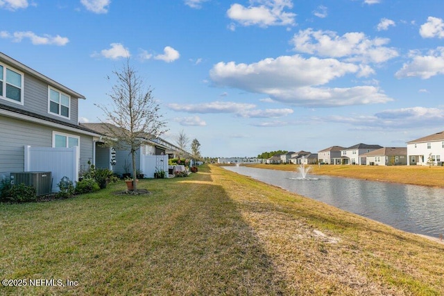 view of yard with a water view and central AC