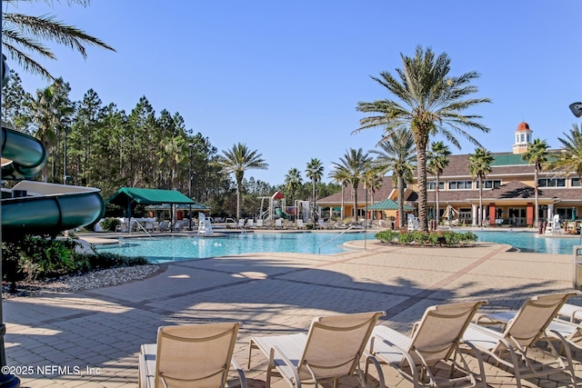 view of swimming pool with a patio and a water slide