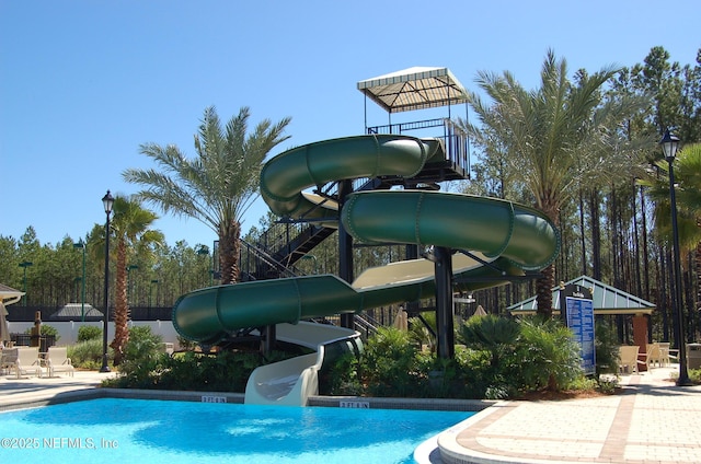 view of pool with a patio and a water slide