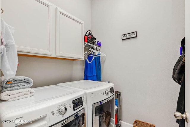 washroom with cabinets and washing machine and clothes dryer