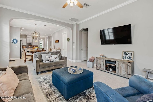 living room with light tile patterned floors, ceiling fan with notable chandelier, and crown molding