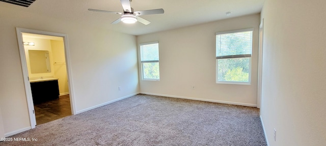 unfurnished bedroom featuring ceiling fan, ensuite bathroom, and carpet flooring