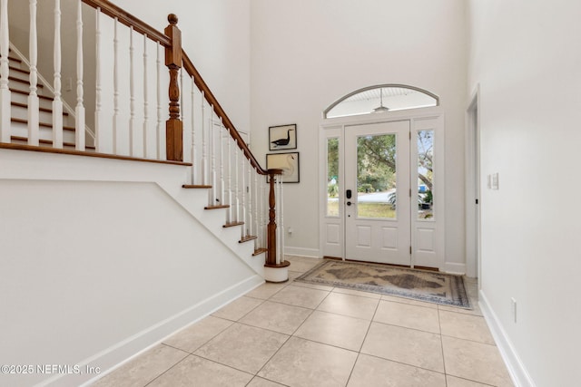 tiled foyer entrance featuring a towering ceiling