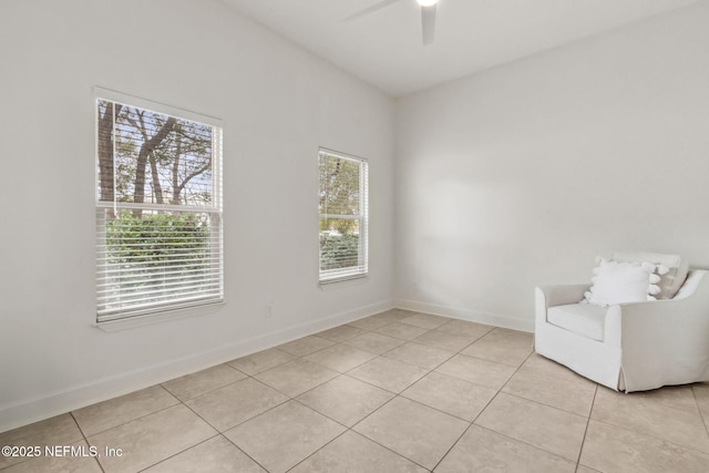 unfurnished room with ceiling fan, a healthy amount of sunlight, and light tile patterned floors