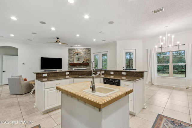 kitchen featuring white cabinetry, sink, a center island with sink, light tile patterned floors, and ceiling fan with notable chandelier