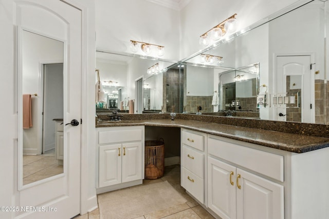 bathroom with tile patterned flooring, vanity, and walk in shower