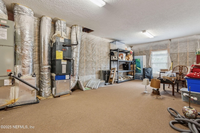 basement with carpet flooring, a textured ceiling, and heating unit