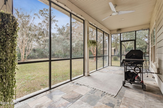 unfurnished sunroom featuring ceiling fan