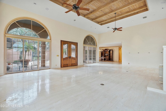 unfurnished living room featuring beam ceiling, ceiling fan, french doors, wooden ceiling, and a high ceiling