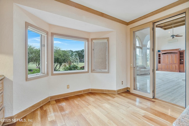 empty room with light hardwood / wood-style flooring, ceiling fan, and crown molding