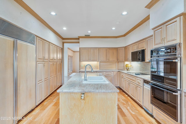 kitchen featuring light brown cabinets, a kitchen island with sink, black appliances, and sink