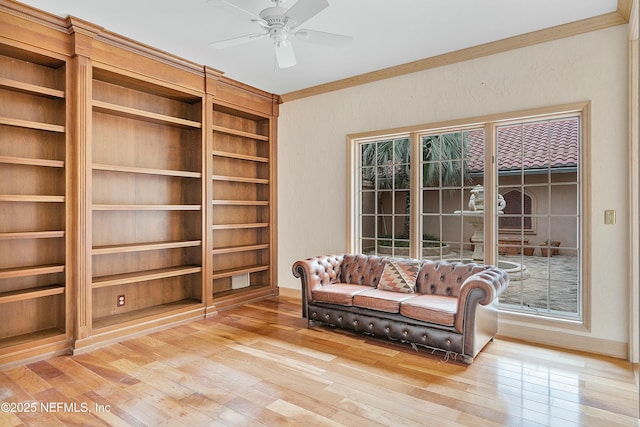 sitting room featuring ceiling fan, built in features, ornamental molding, and hardwood / wood-style flooring