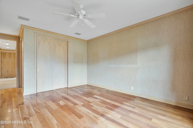 unfurnished bedroom featuring light wood-type flooring, a closet, ceiling fan, and crown molding