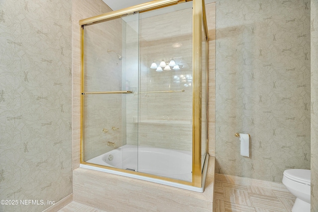 bathroom with tile patterned flooring, enclosed tub / shower combo, and toilet