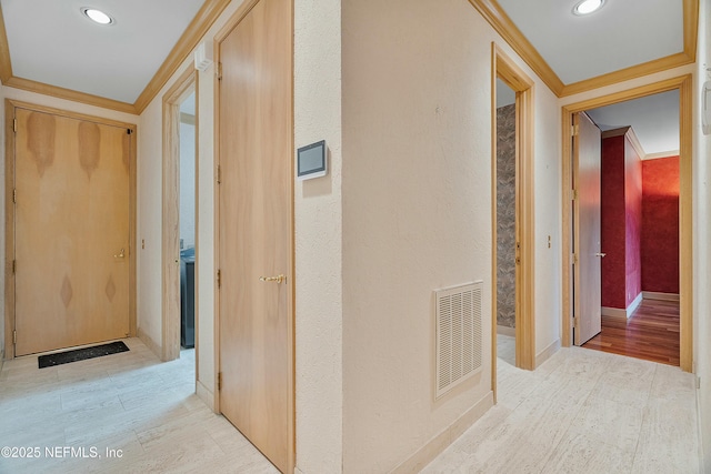 hall featuring crown molding and light hardwood / wood-style flooring