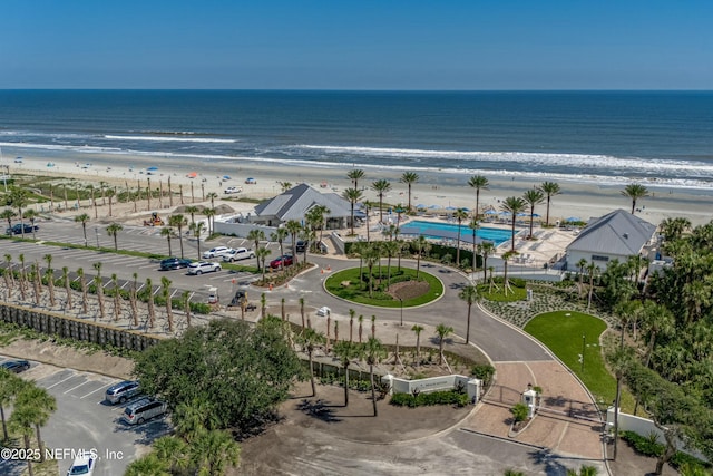 drone / aerial view featuring a water view and a view of the beach