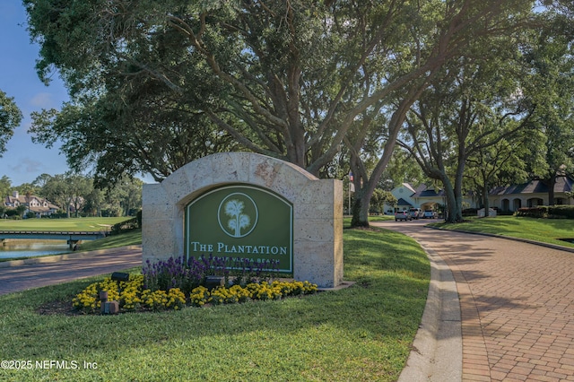 community sign featuring a yard