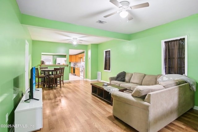 living room with ceiling fan and light wood-type flooring